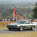 Tom Walkinshaw Racing car on a road with people in the background of the race circuit